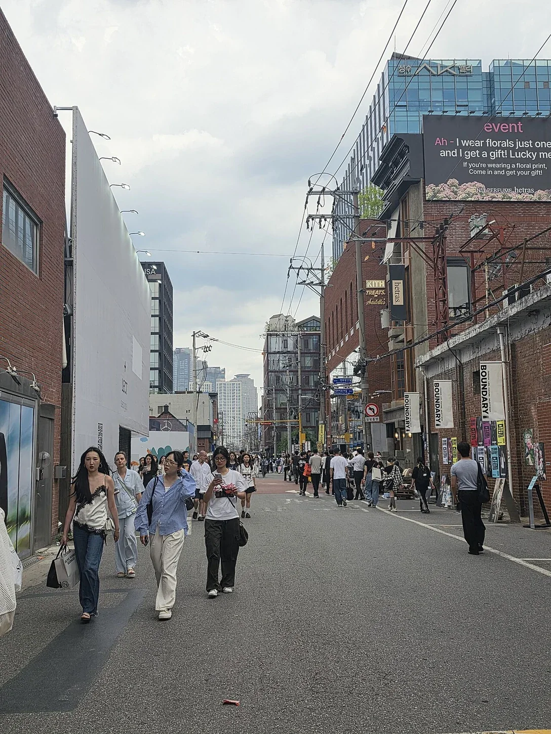 Menschen zwischen Backsteingebäuden und Geschäften in Seongsu