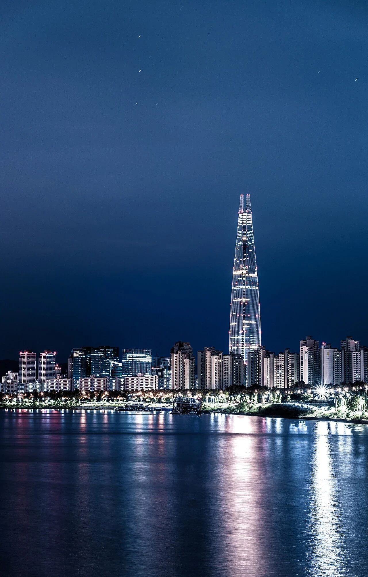 Lotte World Tower und Seouls Nachtpanorama mit Lichtreflexen auf dem Han-Fluss
