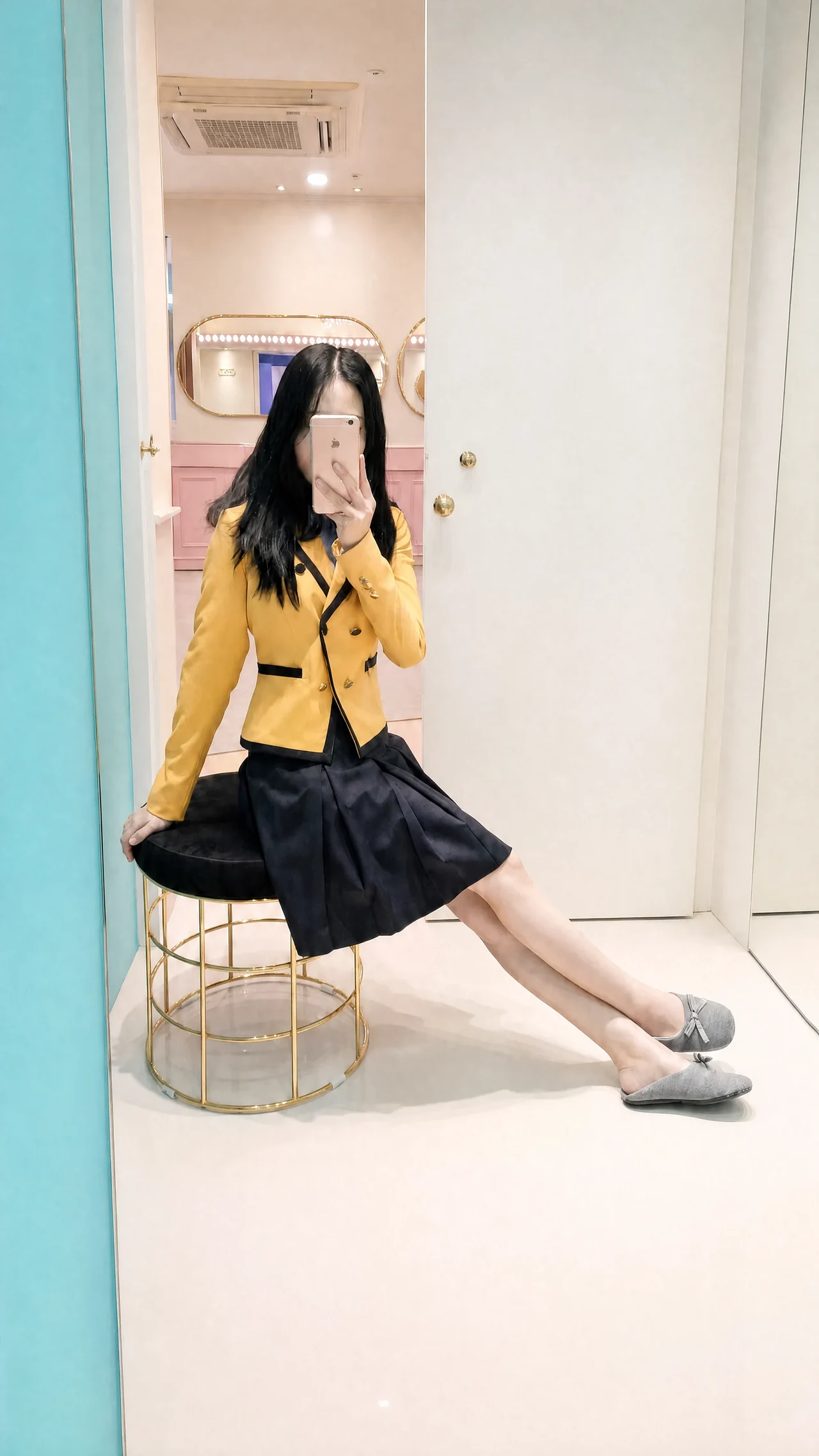 Eine sitzende Besucherin in der gelben Uniform der School of Performing Arts Seoul